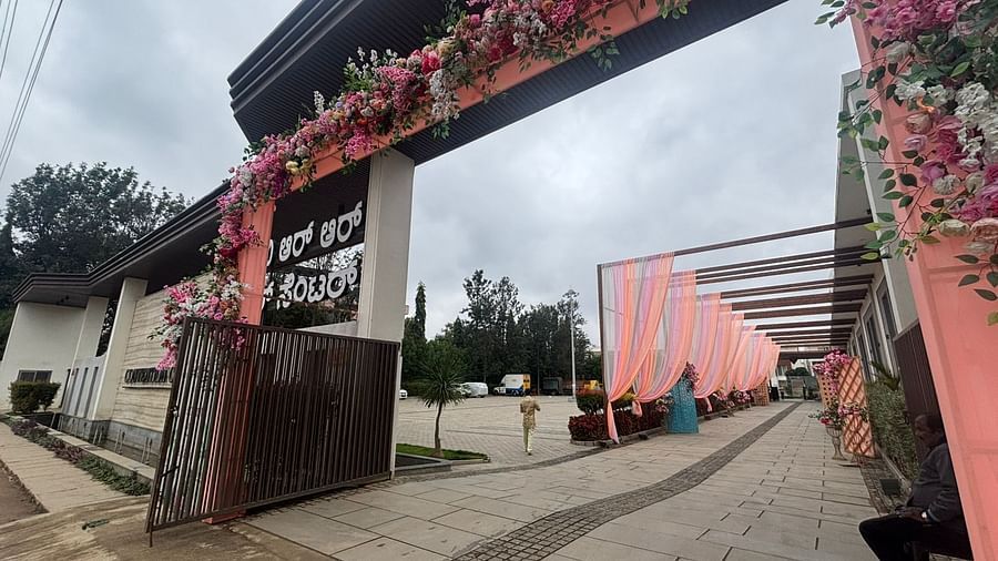 A setup outdoors, with intricate floral designs and green plants as part of the decoration.