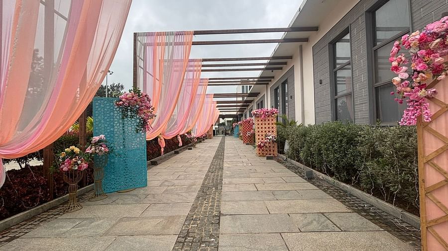 A setup outdoors, with intricate floral designs and green plants as part of the decoration.