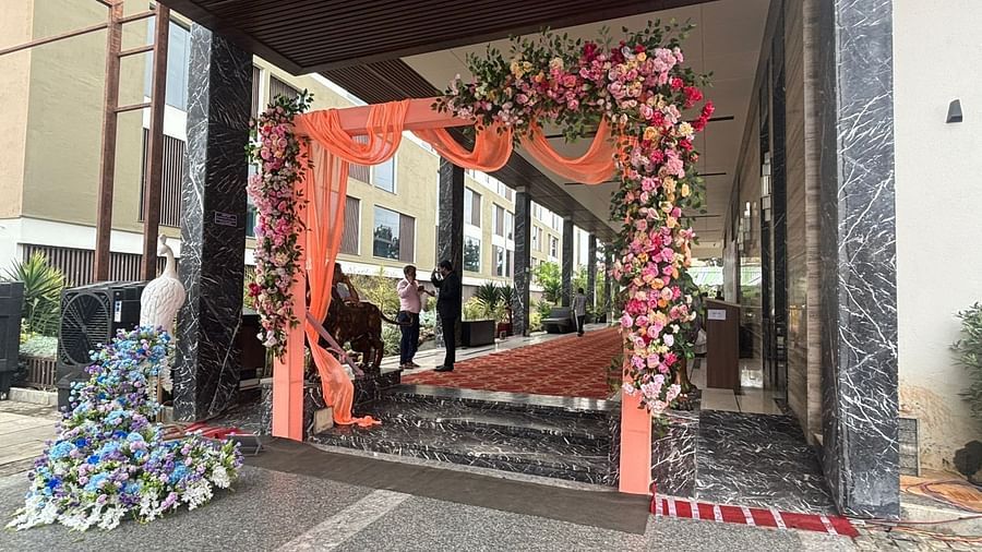 A main gate adorned with pink floral decorations, leading to a beautifully decorated outdoor event space.