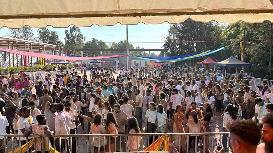 Wide shot of the crowd under a tent, people gathered closely, stage area with equipment visible.
