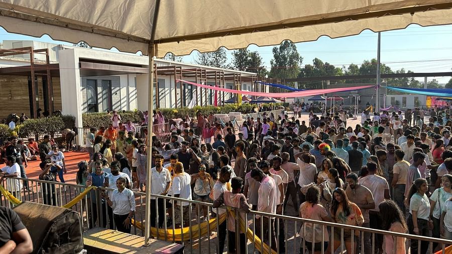 Closer view of the crowd under a tent, people gathered closely, stage visible in the distance.