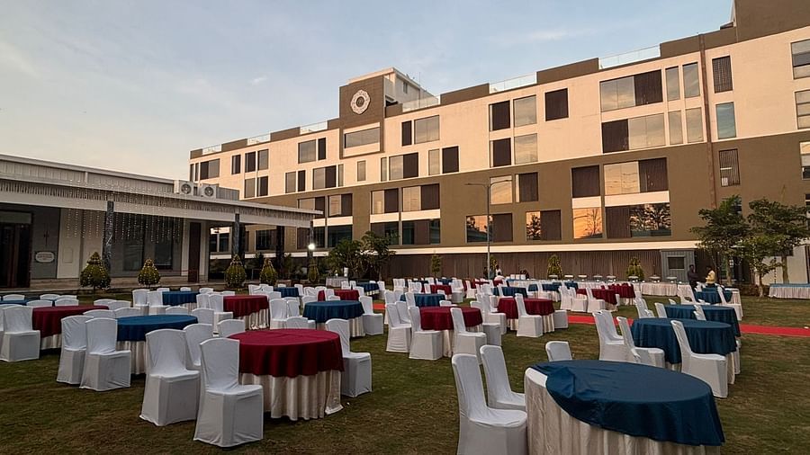 Open-air banquet setup with tables and chairs surrounded by greenery at VRR Astoria.