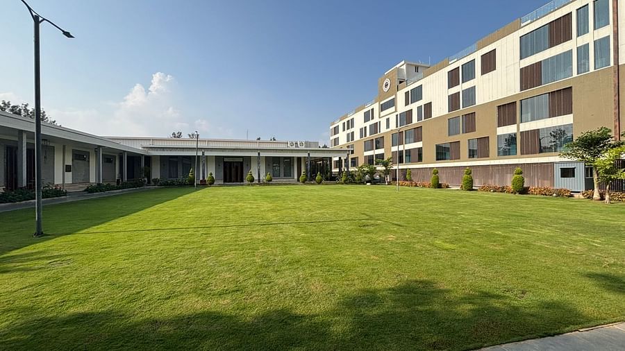 Hotel facade with spacious green garden under clear blue sky