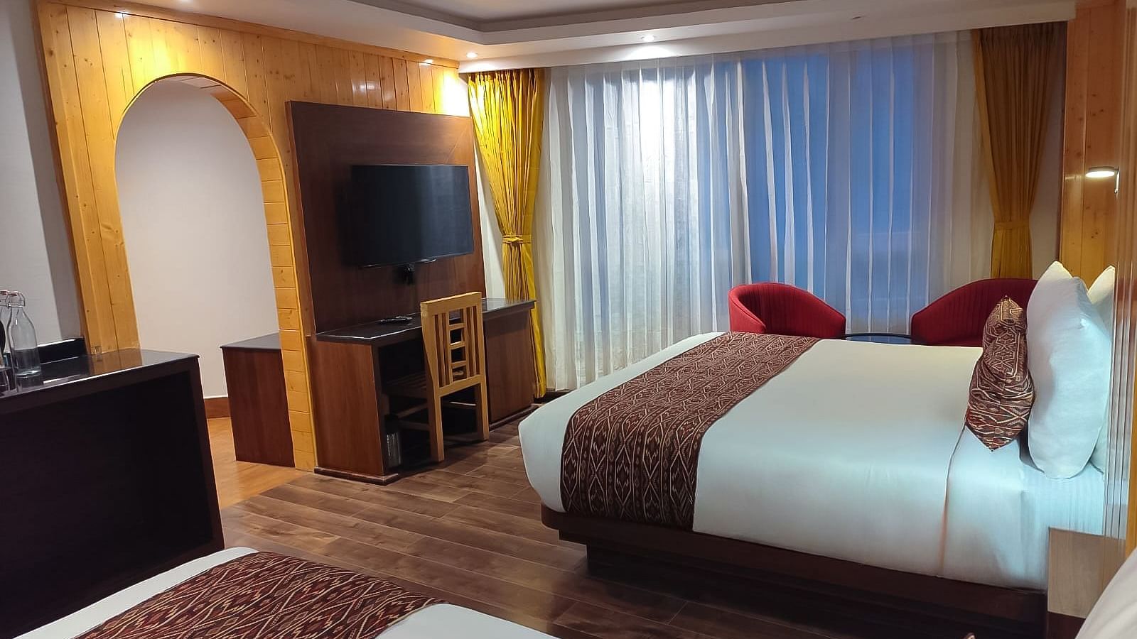 A corner view shot of the Premium Room with a double bed placed right opposite to the TV table - Yashshree Lachen