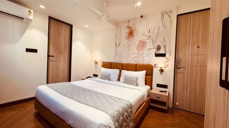 Bright and cosy guest room at Hotel Mumbai House, Vijay Nagar, Indore, offering a comfortable bed, ample storage, and soothing décor for guests.