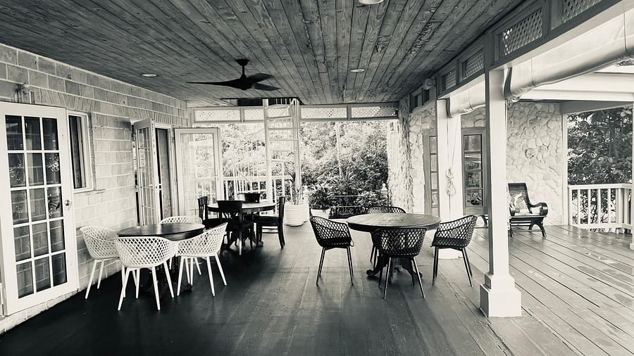Covered wooden patio with empty tables and chairs in a black-and-white filter | A Stone's Throw Away