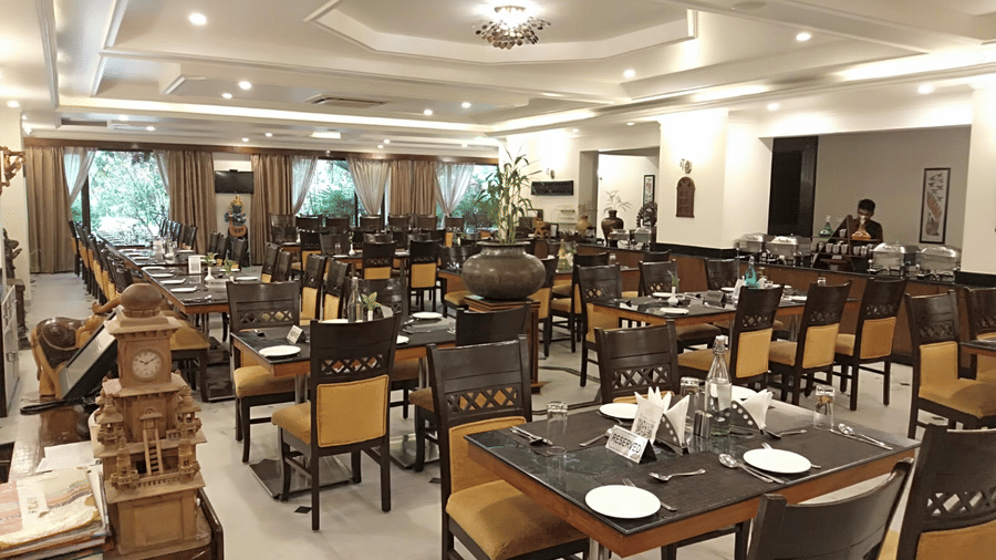 A dining hall with arranged tables and chairs at AS Hotels, Khajuraho.