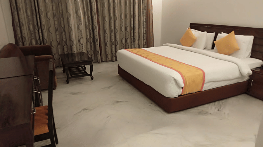 A comfortable room with double bed with modern furnishings and warm lighting at AS Hotels, Khajuraho.