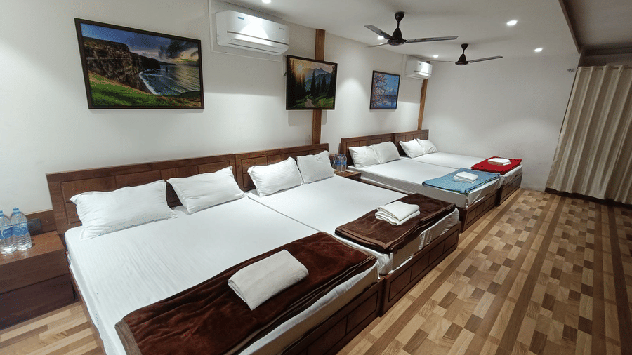 High-capacity guest room with five double beds arranged in a row, ideal for large groups or corporate retreats - DAN Resorts & Weddings, Palghar