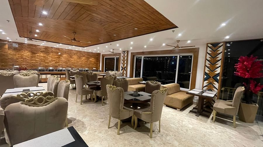 Dining area with comfortable chairs around tables at Rainbow Restaurant at DLS Ark Holiday Inn, Banikhet.