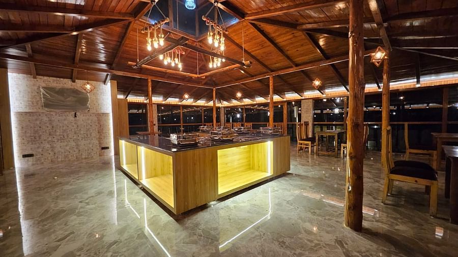 A shot of the restaurant counter taken at night which is lit with bright yellow lighting - DLS The Emerald, Nainital
