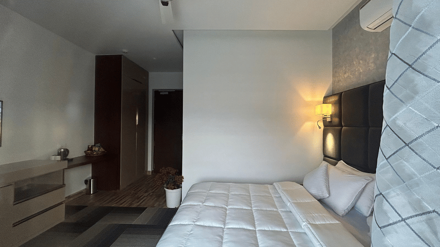 Side view of the Deluxe Room with modern interiors featuring a double bed at Eminence The Corbett - Rooms in Nanital