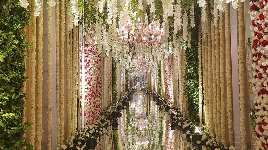 A beautifully decorated wedding aisle with floral arrangements and a crystal chandelier.