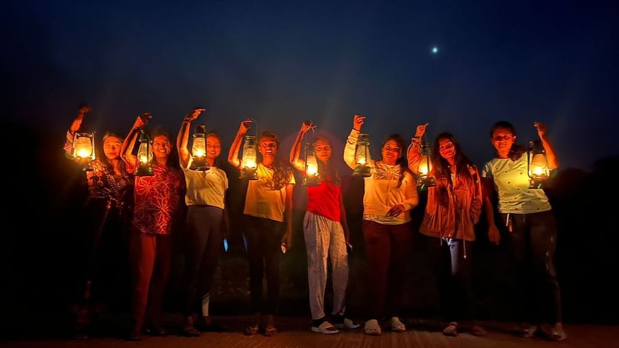 Women posing with lanterns at night, expressing happiness in a natural setting - Evergreen County