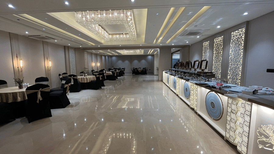 The Sapphire Hall at Hotel 91 Privé, Gurugram, featuring the round tables surrounded by chairs on one side and the buffet counter on the other side.
