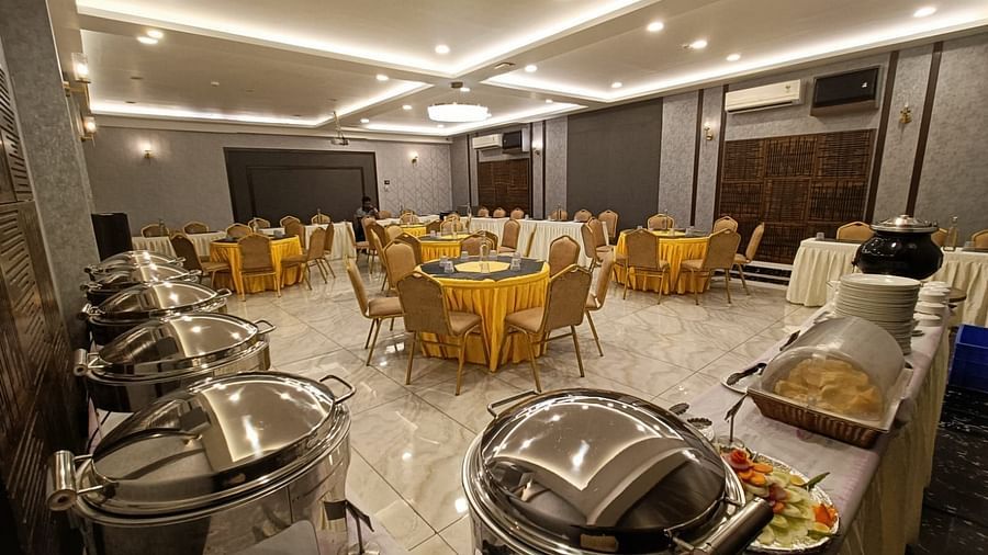 image of event hall with yellow chairs and tables and buffet system placed at the corner at Hotel Eastern Gate, Port Blair