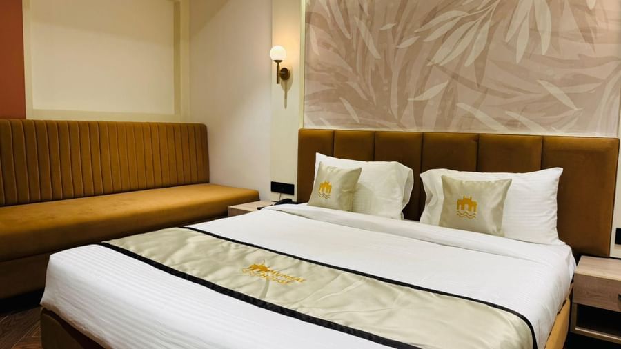 Elegant guest room at Hotel Mumbai House, Vijay Nagar, Indore, featuring a plush double bed, warm lighting, and cosy seating for a relaxing stay.