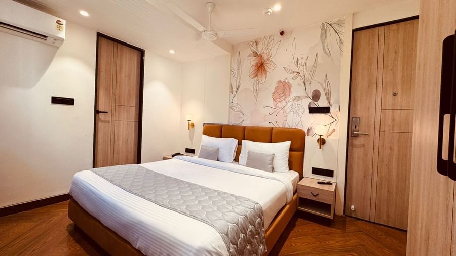 Bright and cosy guest room at Hotel Mumbai House, Vijay Nagar, Indore, offering a comfortable bed, ample storage, and soothing décor for guests.