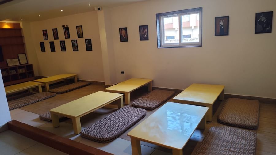 Side view of the floor seating arrangement featuring a small window emitting natural light through it at Ilara Hotels & Spa, Tada.