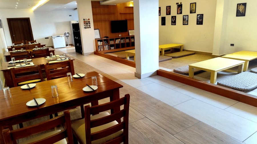 Full view of the Ajito restaurant featuring two types of seating arrangements in a brightly-lit dining area at Full view of the Ajito restaurant featuring several dining tables arranged against the wall at one side at Ilara Hotels & Spa, Tada.