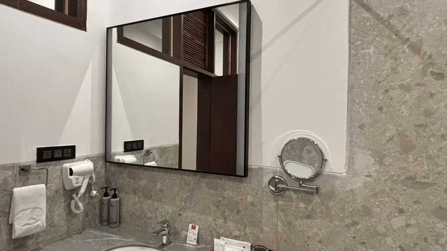 Modern bathroom vanity and mirror at Lords Riverside Resort, Muduba - Shivamogga