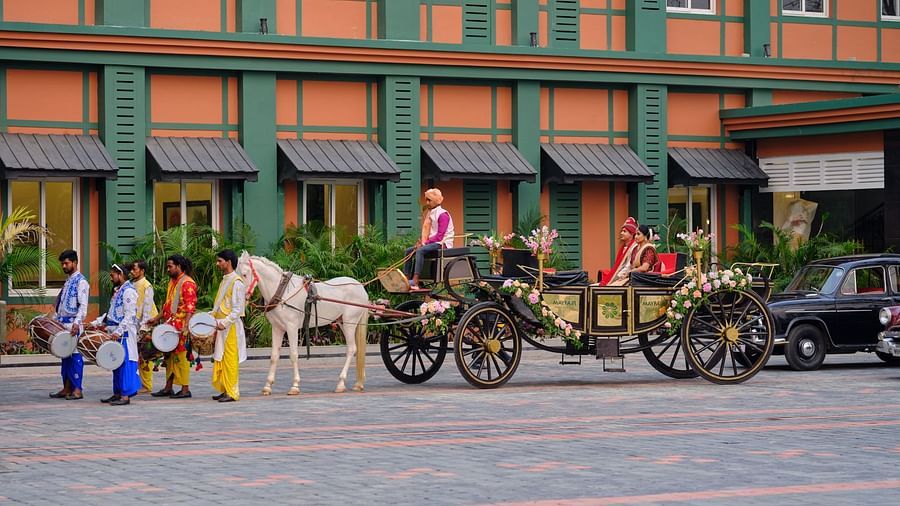 a carriage being driven on which a newly married couple sits - Mayfair Tea Resort, Siliguri 3