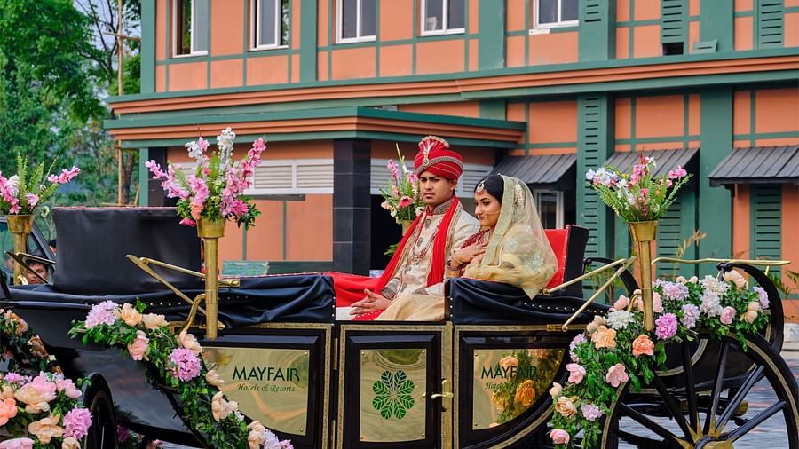 a carriage being driven on which a newly married couple sits - Mayfair Tea Resort, Siliguri 1