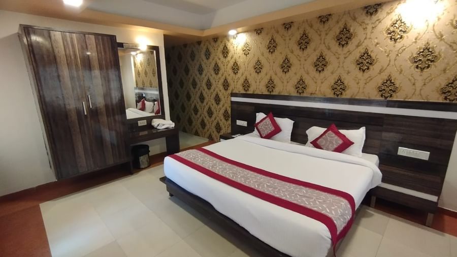 Wide view of the Super Deluxe Room which features a king size bed, bedside tables, and a wardrobe.