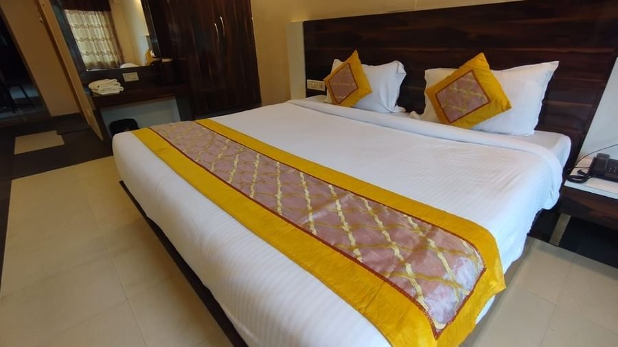 Super Deluxe Room at Mountview Resort furnished with a carpeted king size bed, a wardrobe,  and bedside tables.