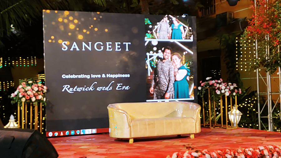 Stage with large digital screen reading 'Sangeet' and floral decor at Paradise Lagoon Resort, Udupi.