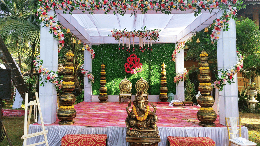 Outdoor wedding stage with floral canopy, and pink seating area at Paradise Lagoon Resort, Udupi.