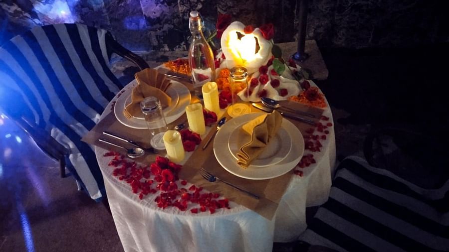 Romantic outdoor dinner setup with candles and rose petals, offering a serene and intimate dining experience - Sea Hills Resort, Swaraj Dweep (Havelock)