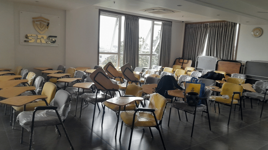 A full view of the Training Centre at SRS Suites, Koramangala, featuring seminar chairs with attached table flaps facing towards one direction.