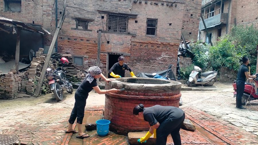 Two men seen cleaning a well