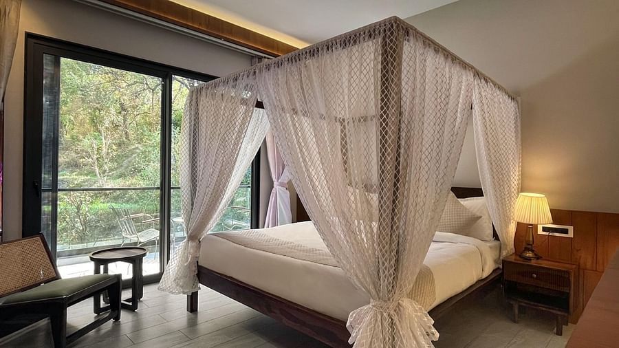 A hotel room with a beautiful bed with a glass door opening to the balcony - The Samai, Bhimtal