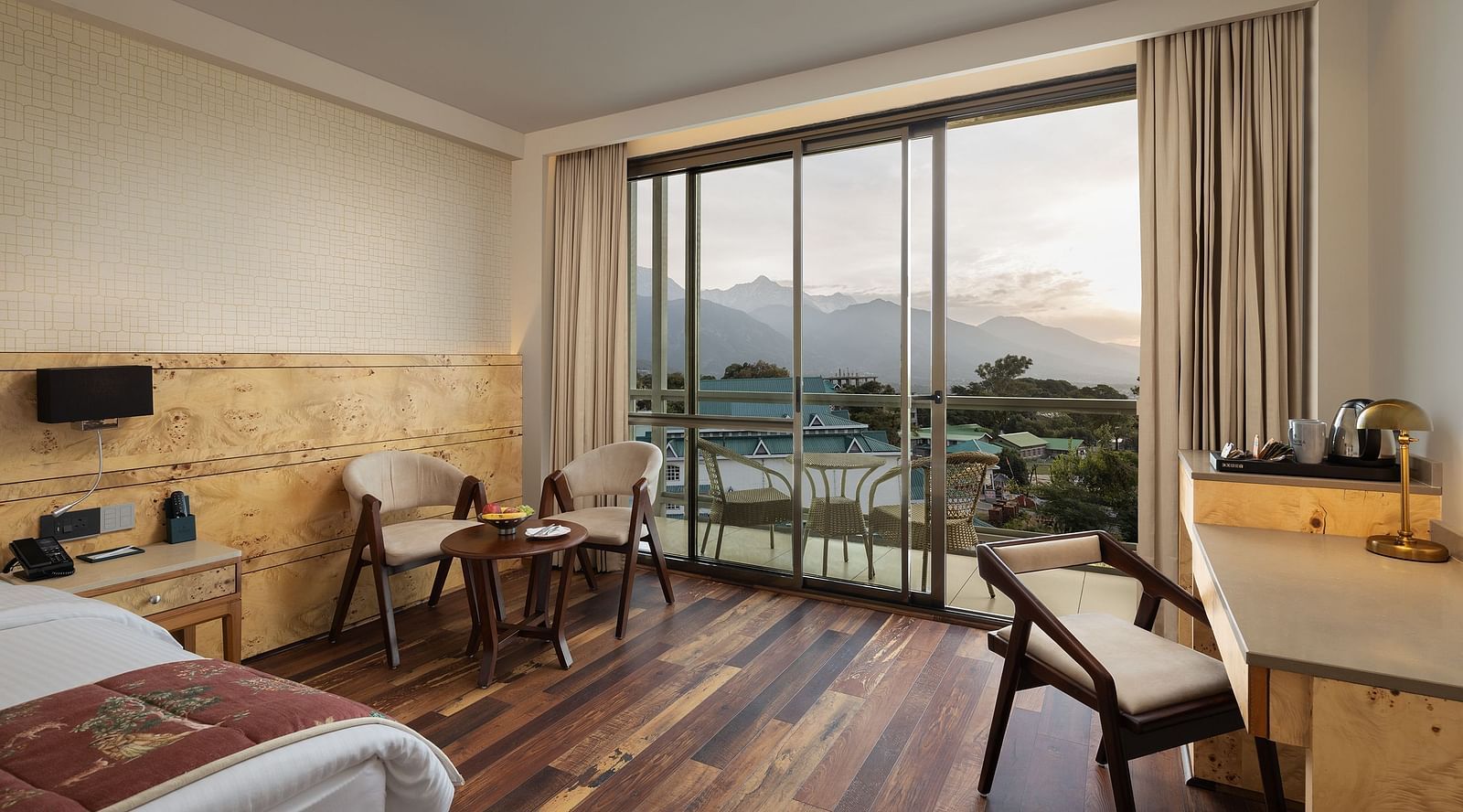INFINITEA executive room with a double bed, chairs and a television at Infinitea Centric, Dharamshala
