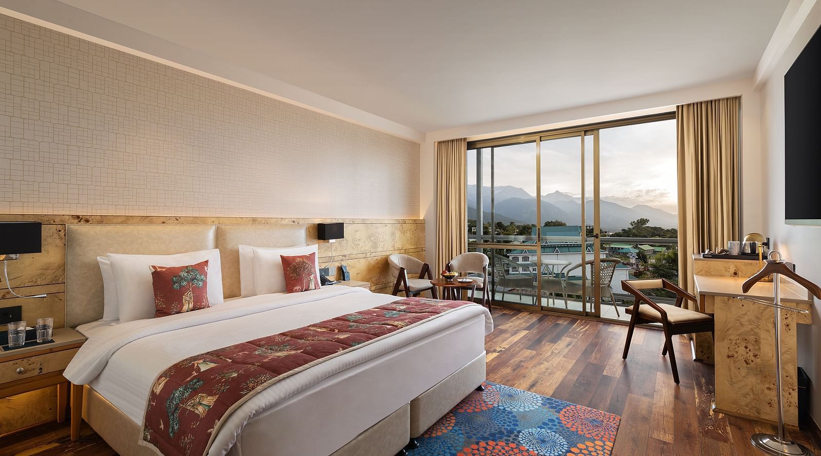 INFINITEA Executive room with a king size bed and a balcony with mountain views.