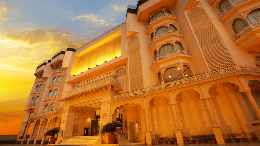 Golden Tulip Jaipur City Center facade with a sunset sky in the backdrop.