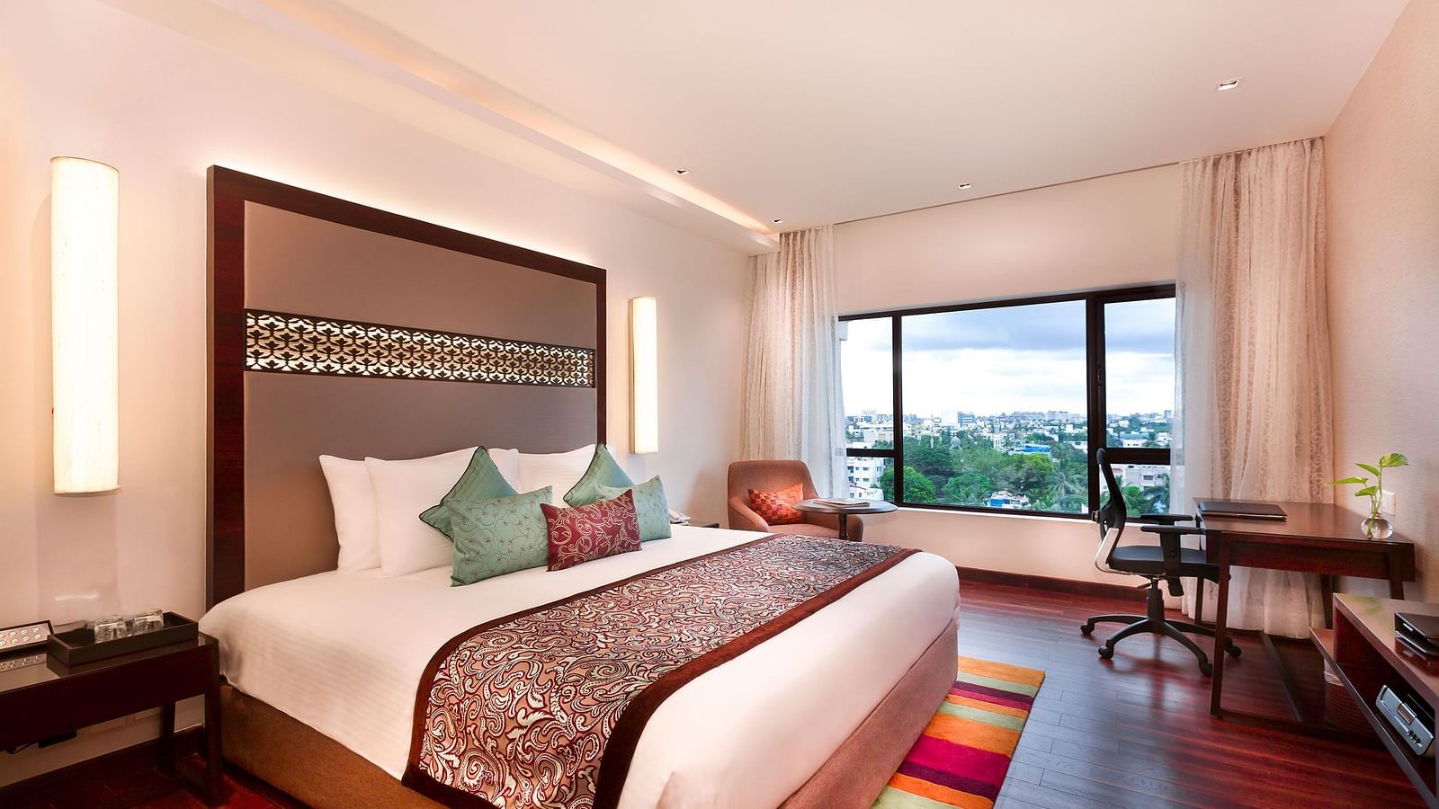 Serene Room with a king size bed and a work desk with a chair at Grand Chennai By GRT Hotels.