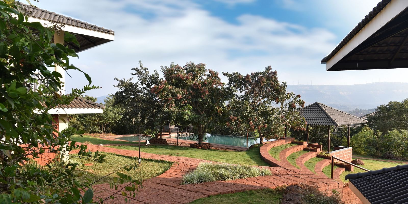 Captured at Forest Escape, this image offers a wider view of the resort grounds with gardens and trees under a partly cloudy sky.