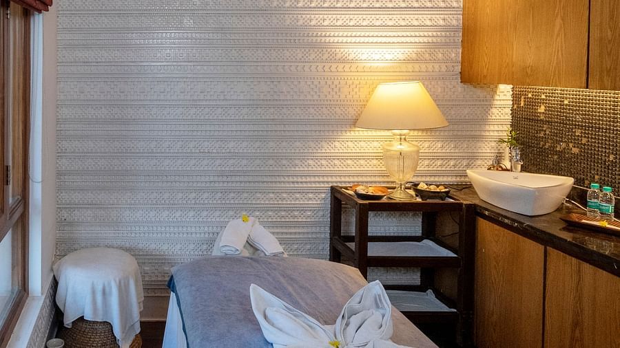 Cozy and peaceful spa area with a single bed and a lamp in the corner at The Claridges Nabha Residence