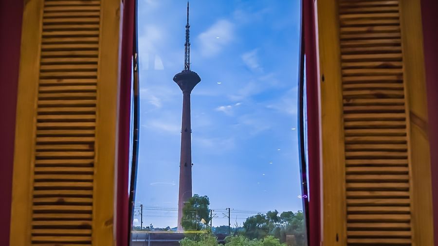 An image of a tower in a faraway place which is viewed from a window - Themis Barbecue House, NSP Pitampura