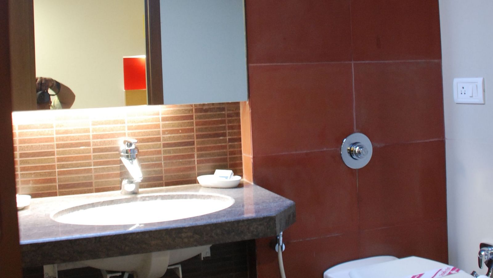 Image of a washroom with sink and mirrors and modern amenities at The Oriental Residency