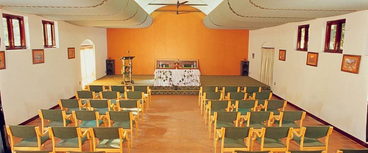 A back view of chairs placed in classroom seating in a closed hall | Vythiri Resort, Wayanad