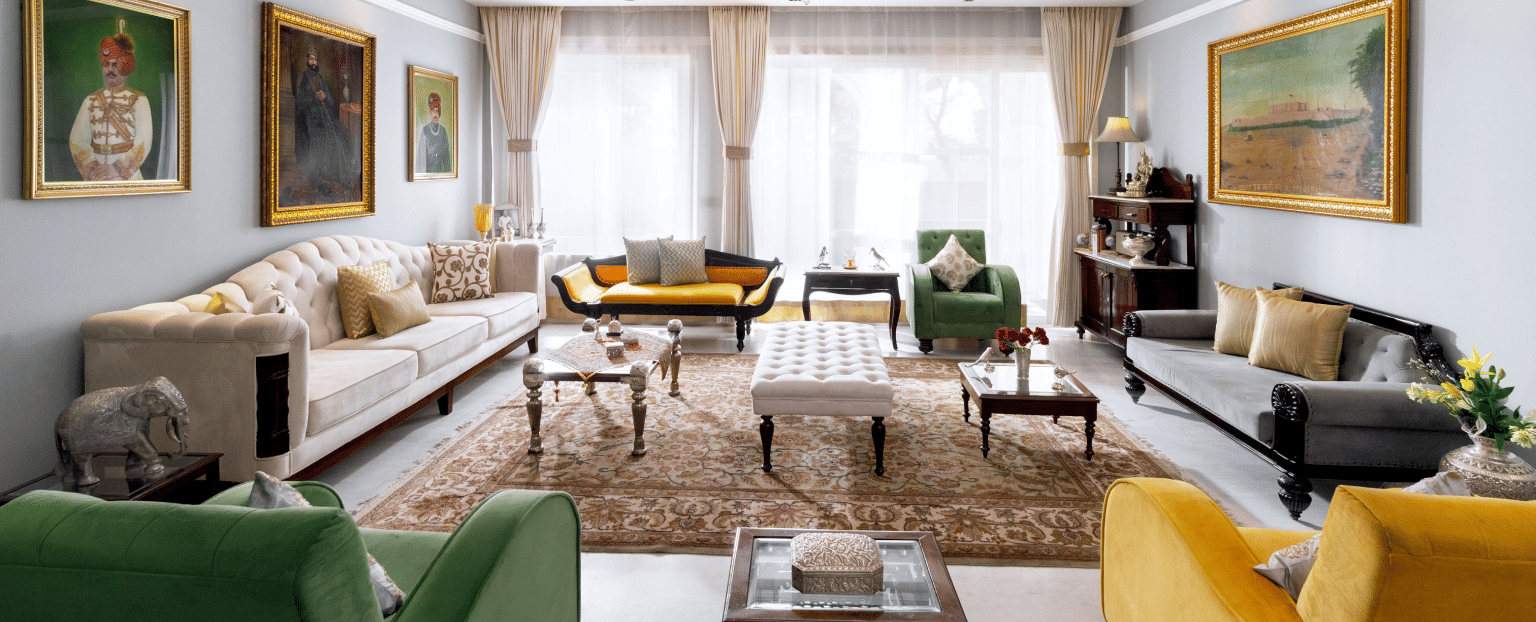 Guest lounge area at Dileep Kothi, Jaipur with sofa arrangement and photographs hung on the walls