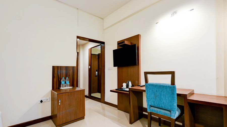 The Pamposh, New Delhi | A room with tables, a chair, and doors.