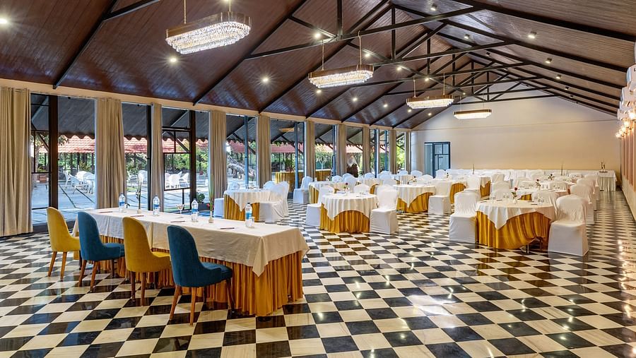 corner view of the banquet hall in udaipur with a high ceiling and properly arranged chairs and tables