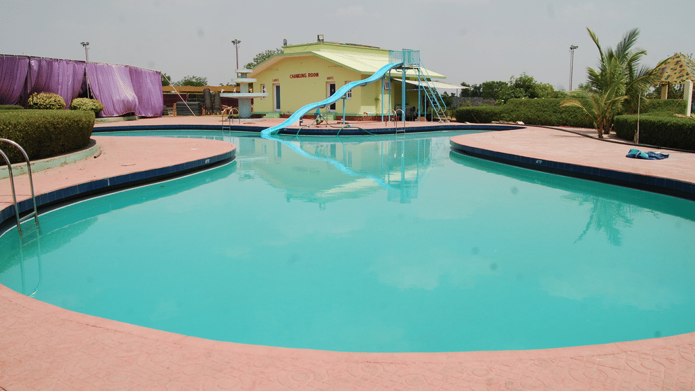 Swimming pool and party lawn at The Palm Resort, a luxury resort in Bhilwara