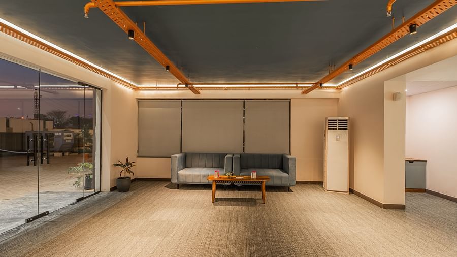 Lounge area featuring contemporary seating, sleek design, and large windows at Clarks Inn Suites Jaipur, Ajmer Road