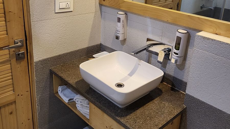 A modern bathroom with a wall-mounted sink, a vanity, and a mirror at Dagshai Manor Kasauli - Inde Hotels.